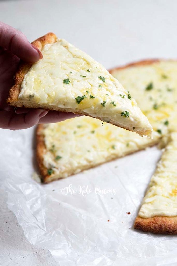 an image of a slice of keto 3 cheese white pizza on a fathead pizza crust