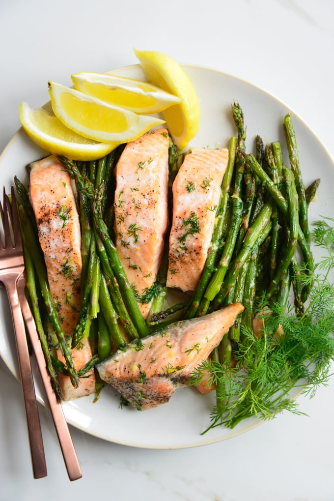 keto salmon recipe for poached salmon on a plate with asparagus and lemon slices 